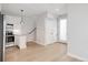 Open-concept living and kitchen area featuring modern fixtures, stainless appliances, and light hardwood floors at 4232 Jason St # 2, Denver, CO 80211