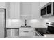 This modern kitchen features sleek white cabinetry, stainless steel appliances, and a stylish black faucet at 4232 Jason St # 2, Denver, CO 80211