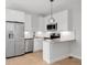 Modern kitchen featuring sleek appliances, white cabinets, a small island, and stylish pendant lighting at 4232 Jason St # 2, Denver, CO 80211