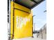 Bright yellow wall with 'Sunny Side Up' sign, staircase, and street lights at 4232 Jason St # 2, Denver, CO 80211