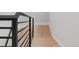 Modern staircase with light wood treads and a black metal railing against a white wall at 4232 Jason St # 2, Denver, CO 80211