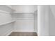 A simple walk-in closet is all white with shelving and carpeted floors at 4232 Jason St # 2, Denver, CO 80211