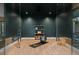 Bright home gym with a dark accent wall, light hardwood floors, exercise ball, yoga mat, and open shelving at 2580 Saddleback Dr, Castle Rock, CO 80104
