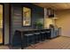 Outdoor kitchen with stainless steel appliances, bar seating, and modern finishes on the covered patio at 2580 Saddleback Dr, Castle Rock, CO 80104