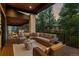 A spacious outdoor living area with ample seating options, a stone column, and a view of the trees at 2580 Saddleback Dr, Castle Rock, CO 80104