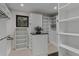 Organized walk-in closet features ample shelving, hanging rods, and central island for storage at 2580 Saddleback Dr, Castle Rock, CO 80104