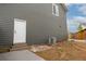 Exterior view of backyard featuring a door, AC unit, and gray siding at 643 Ranchhand Dr, Berthoud, CO 80513