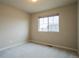 This bedroom has neutral carpeting and paint and a large window providing plenty of natural light at 643 Ranchhand Dr, Berthoud, CO 80513