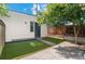 Small backyard area featuring artificial turf, a concrete patio, fence and door at 2745 Java Ct, Denver, CO 80211