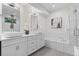 Bright bathroom with dual sinks, marble accents, a soaking tub and natural light at 2745 Java Ct, Denver, CO 80211