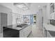 Open kitchen with island cooktop, modern cabinetry, and view to dining area with fireplace at 2745 Java Ct, Denver, CO 80211