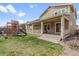 Inviting backyard featuring a covered patio, lush lawn, and a wooden playset for outdoor fun and relaxation at 14938 Vienna Cir, Parker, CO 80134