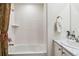Bright bathroom featuring a shower and tub combination with white tile surround and white vanity at 14938 Vienna Cir, Parker, CO 80134