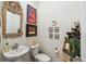 Charming powder room with decorative mirror, pedestal sink and fun artwork at 14938 Vienna Cir, Parker, CO 80134