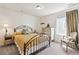 This bright bedroom features a metal bed frame, side table, dresser, and window at 14938 Vienna Cir, Parker, CO 80134