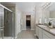 The bathroom showcases a glass-enclosed shower, double sink vanity, and views to the bedroom and walk-in closet at 7536 Grady Cir, Castle Rock, CO 80108