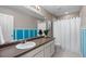 Bright bathroom with modern blue accents, a toilet, shower, and white cabinets at 7536 Grady Cir, Castle Rock, CO 80108