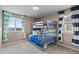 Bedroom with bunkbeds, two large windows, carpet, and decorative curtains at 7536 Grady Cir, Castle Rock, CO 80108