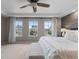 Primary bedroom with accent wall, ceiling fan, and large windows overlooking neighborhood at 7536 Grady Cir, Castle Rock, CO 80108