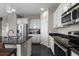 Well-equipped kitchen with stainless steel appliances, granite countertops, white cabinets, and a center island with a sink at 7536 Grady Cir, Castle Rock, CO 80108