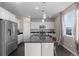 Modern kitchen with stainless steel appliances, granite countertops, an island with seating, and bright natural light from a nearby window at 7536 Grady Cir, Castle Rock, CO 80108