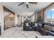 Bright living room with a leather sectional sofa, large windows, and an open floor plan leading to the kitchen at 7536 Grady Cir, Castle Rock, CO 80108
