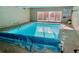 Inviting indoor pool with a bright blue cover, with a posted sign and large sliding glass doors at 1050 N Lafayette St # 101, Denver, CO 80218