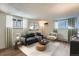 Staged living room with sofa, chair, rug, and windows, creating a comfortable and inviting space at 1050 N Lafayette St # 101, Denver, CO 80218