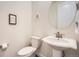 Powder bathroom with a pedestal sink, a round mirror, and a toilet at 946 Compass Dr, Erie, CO 80516
