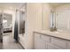 Stylish bathroom with gray tile surround, a large mirror, and access to the bedroom at 946 Compass Dr, Erie, CO 80516