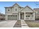 Beautiful exterior showcases a covered front porch and a well-maintained lawn with rock landscaping at 946 Compass Dr, Erie, CO 80516