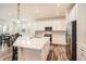 Modern kitchen features white cabinetry, stainless steel appliances, and a large island with hardwood floors at 946 Compass Dr, Erie, CO 80516