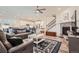 Open concept living room showcasing a fireplace, hardwood floors, and seamless flow to the kitchen at 946 Compass Dr, Erie, CO 80516