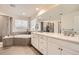 Main bathroom featuring dual sinks, soaking tub, and a walk-in shower at 946 Compass Dr, Erie, CO 80516