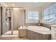 Main bathroom featuring a soaking tub and separate walk-in shower at 946 Compass Dr, Erie, CO 80516
