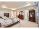 Large main bedroom featuring a tray ceiling, carpeted floors, and generous closet space at 946 Compass Dr, Erie, CO 80516