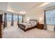 Spacious main bedroom featuring a tray ceiling, large windows, and carpeted floors at 946 Compass Dr, Erie, CO 80516