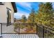 Back deck with black metal railings and views of trees and mountains in the distance at 1803 Avenida Del Sol, Castle Rock, CO 80104