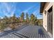 Exterior balcony showcasing the wood-paneled floor and scenic view of the nearby trees at 1803 Avenida Del Sol, Castle Rock, CO 80104