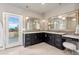 Elegant bathroom with double vanity, decorative mirrors, and an exterior door to the balcony at 1803 Avenida Del Sol, Castle Rock, CO 80104