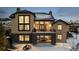 Rear exterior showcasing the home's stonework, upper level deck, covered patio, and snowy backyard at 1803 Avenida Del Sol, Castle Rock, CO 80104