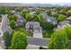 Expansive aerial view of a home nestled among mature trees with mountain views in the distance at 5683 Fig Way, Arvada, CO 80002