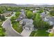 Beautiful aerial view of a suburban home with a well-manicured lawn and a tree-lined street surrounded by lush greenery at 5683 Fig Way, Arvada, CO 80002