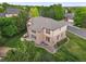 Aerial view of a brick home with a patio and fenced backyard surrounded by mature trees at 5683 Fig Way, Arvada, CO 80002