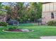 Landscaped backyard with a lush lawn, mature trees, and a charming garden bed at 5683 Fig Way, Arvada, CO 80002