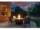 Outdoor patio with a charming fire pit, comfortable seating, and a beautiful evening sky at 5683 Fig Way, Arvada, CO 80002
