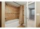 Bathroom with tiled shower and tub featuring glass enclosure and a neutral color palette at 5683 Fig Way, Arvada, CO 80002