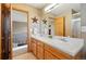 Well-lit bathroom with double sinks, a large mirror, and a walk-in closet nearby at 5683 Fig Way, Arvada, CO 80002