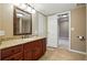 Bathroom featuring a vanity with granite countertop, warm wood cabinets, and tile flooring at 5683 Fig Way, Arvada, CO 80002