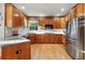 Spacious kitchen features stainless steel appliances, wood cabinetry, and granite countertops at 5683 Fig Way, Arvada, CO 80002